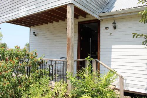a front porch of a white house with a black door at CAJIMA Villa 2 in San Ignacio