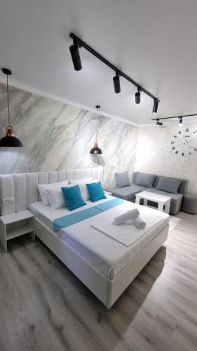 a white bedroom with a bed and a couch at Квартиры на Арбате 2 комнатные in Shymkent