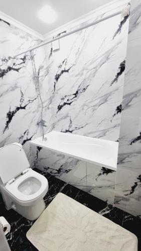 a black and white bathroom with a toilet and a tub at Квартиры на Арбате 2 комнатные in Shymkent