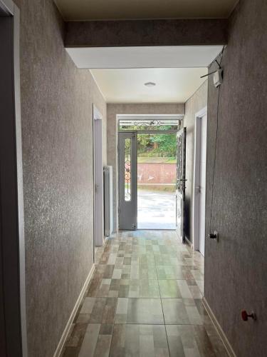 an empty hallway with a door and a tile floor at მაკას სასტუმრო in Chiatʼura
