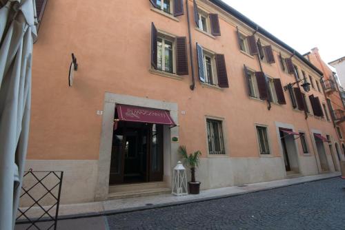 a building with a red awning on a street at Albergo Mazzanti in Verona