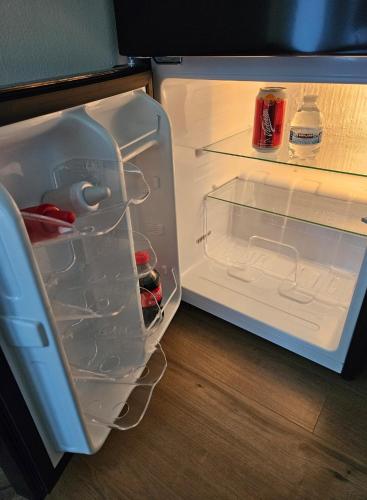 an open refrigerator filled with drinks and bottles ofetchup at Hermosa SUITE vista increíble, gym, elevador in Mexico City