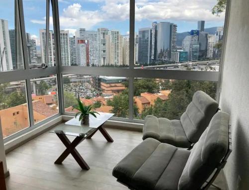 a living room with two chairs and a large window at Hermosa SUITE vista increíble, gym, elevador in Mexico City