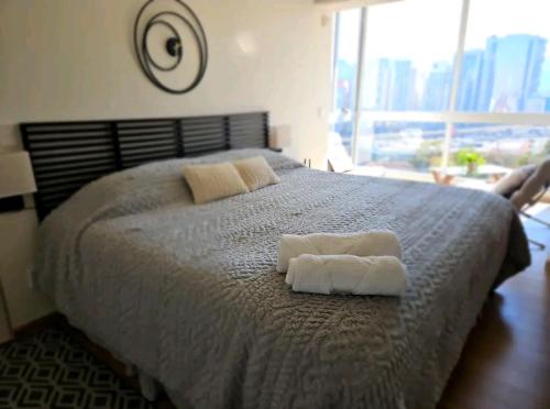 a bedroom with a bed with two towels on it at Hermosa SUITE vista increíble, gym, elevador in Mexico City