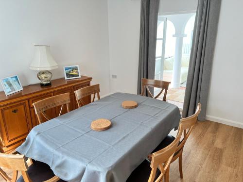 a dining room with a blue table with chairs at Sennen Cove Cottage in Sennen Cove