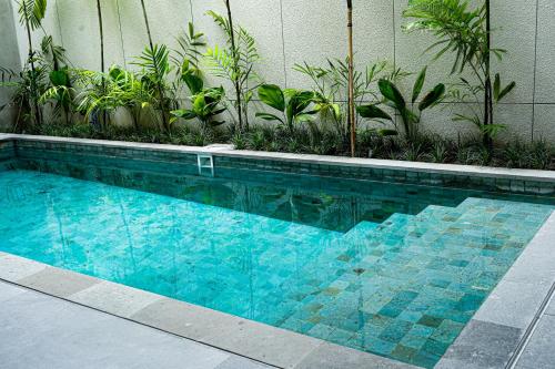 a blue swimming pool with plants in a building at Villa Mamakami - 3BR Luxury Villa in Canggu in Canggu