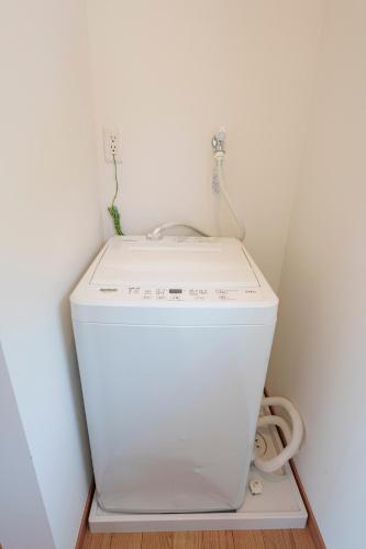 a small white washer and dryer in a room at VILLA KAWAZU - Umi - in Mitaka