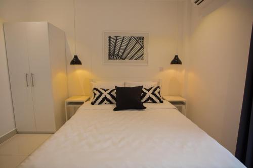 a bedroom with a large white bed with two pillows at Accra Luxury Apartments at Embassy Gardens in Accra