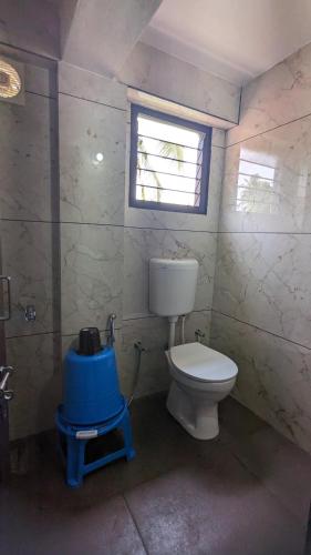 a bathroom with a toilet and a window at Janardhana Residency in Dharmastala