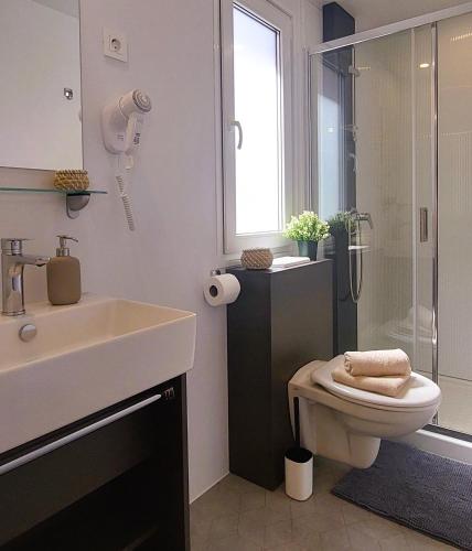 a bathroom with a sink and a toilet and a shower at SEA HOUSE mobile home, pool, bikes, SUP - PRIVILEGE POINT camping & villas in Orebić