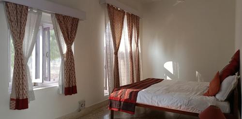 a bedroom with a bed and two windows at Savista Retreat in Jaipur