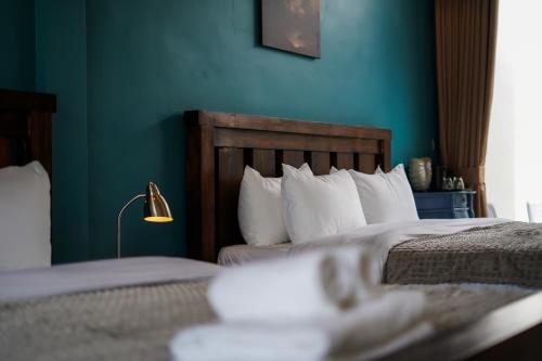 a bedroom with two beds and a blue wall at STONE AGE Boutique in Kampot