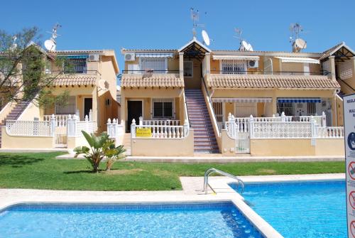 a house with a swimming pool in front of it at Bungalow Lomas Del Golf in San Miguel de Salinas