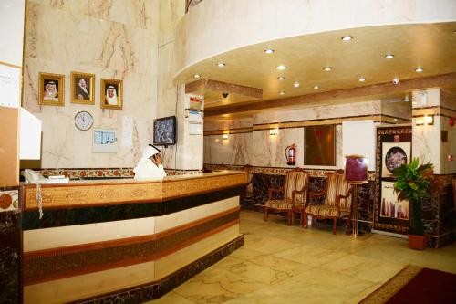 a person sitting at a bar in a restaurant at Nada Al Deafah Hotel in Mecca