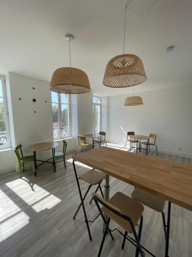 a room with a table and chairs and windows at Chambre avec salle de bain privative, Louhans Centre Ville in Louhans