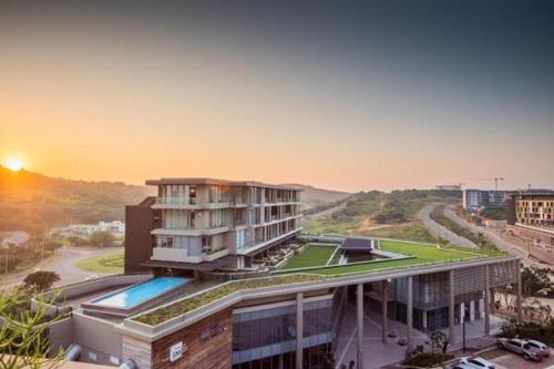 a building with a swimming pool next to a street at Umhlangha Oceans Dunes in Umhlanga