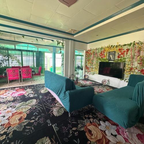 a living room with two blue chairs and a television at Joy O Hoy Beach House in Santander
