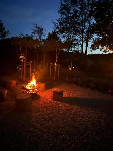 a fire pit in a yard at night at La CABANE LUXUEUSE AVEC JACUZY in Lavacherie
