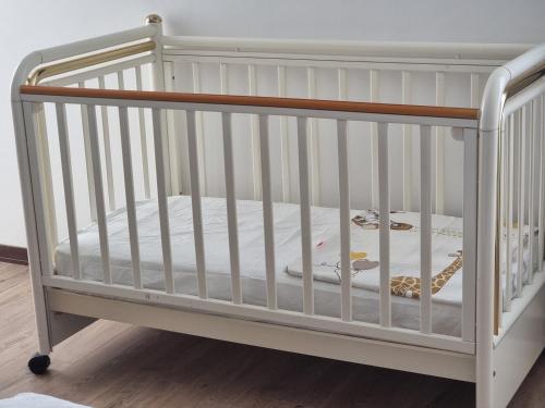 a white crib with a wooden frame and a mattress at Bed and breakfast Biancalana in Petritoli