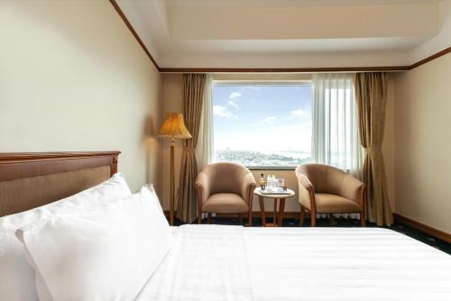 a hotel room with a bed and a table with chairs at A25 Luxury Hotel in Hanoi