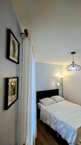 une chambre avec un lit et deux tableaux au mur dans l'établissement Peaceful appartment in la Ciotat, à La Ciotat