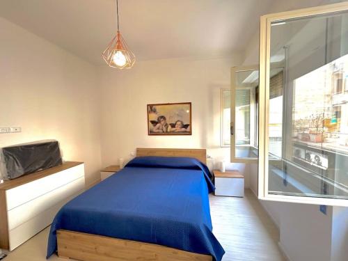 a bedroom with a blue bed and a large window at Casa Alessandra in Alassio