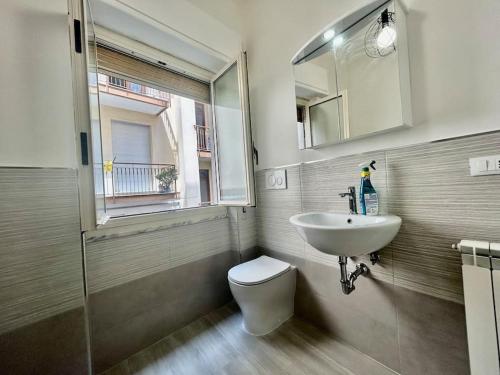 a bathroom with a sink and a toilet and a window at Casa Alessandra in Alassio