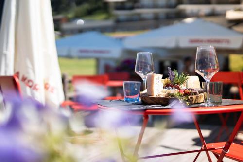 a table with wine glasses and a plate of food at CHALET DES ALPES in Gressan