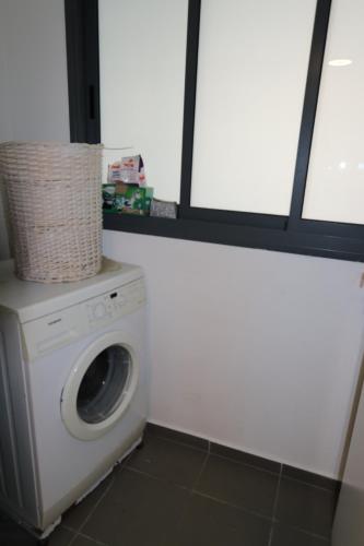 a washing machine in a room with a window at Assuta family in Tel Aviv