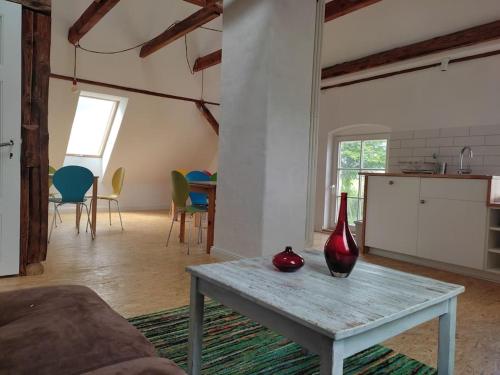 a living room with a table with a red vase on it at Weit draußen und doch mittendrin im Apartment in Thedinghausen