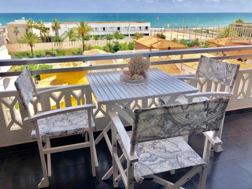 a table and chairs on a balcony with a view of the ocean at La casa de la playa in Piles