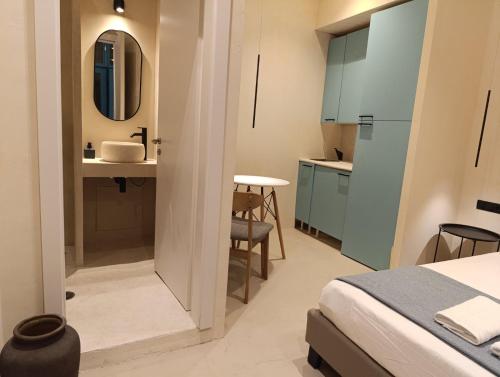 Un dormitorio con una cama y un baño con lavabo. en Syros Experience - Smart Suite, en Ermoupoli