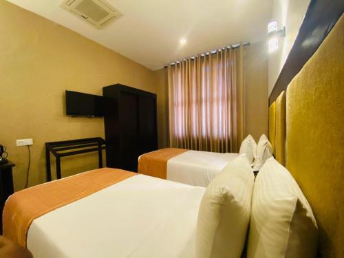 a hotel room with two beds and a window at The Full Moon Hotel Katunayake in Katunayake