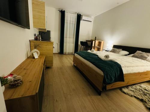 a bedroom with a large bed and a wooden desk at Apartment Luxury B in Slavonski Brod