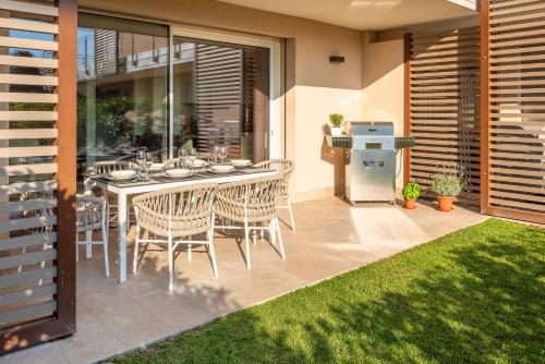 a patio with a table and chairs and a refrigerator at Lifestyle Apartments Dante in Bardolino