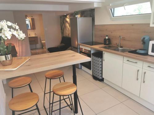 - une cuisine avec des tabourets en bois et un évier dans l'établissement Appartement Cosy 2-4 personnes avec terrasse, à Marlens