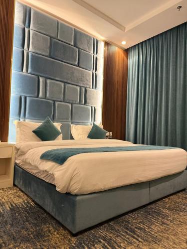 a bedroom with a large bed with a large headboard at شقق ارين المطار in Jeddah
