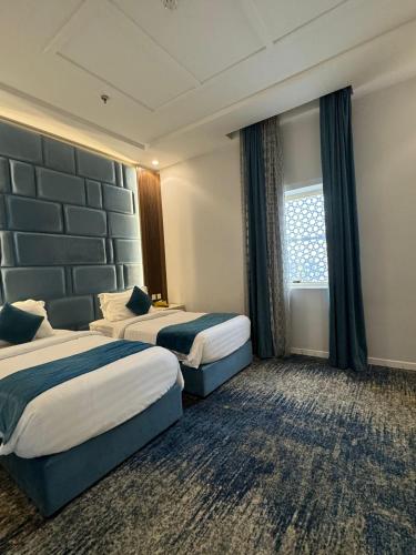 a hotel room with two beds and a window at شقق ارين المطار in Jeddah