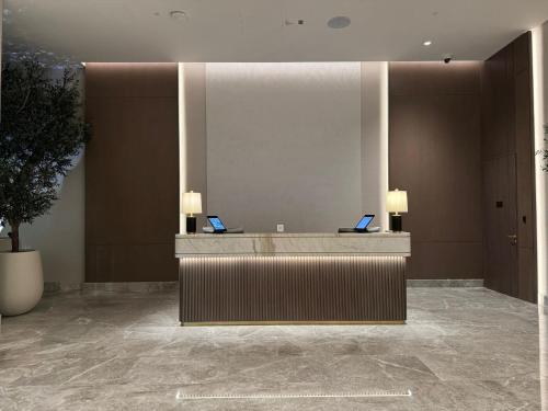 a lobby with a reception desk with two laptops on it at Address Beach Resort Residence Bahrain in Rayyā