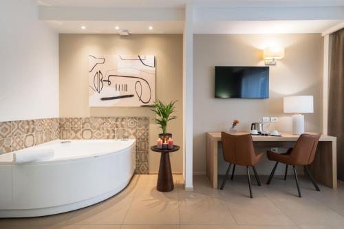 a bathroom with a tub and a table and a desk at Hotel Dimorae Rooms and Suites - Apartments in Civitanova Marche