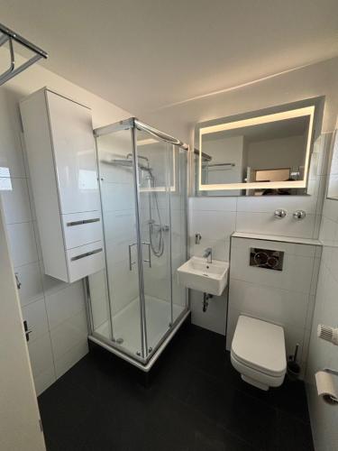 a bathroom with a shower and a toilet and a sink at Exklusive Moderne Wohnung Gießen Stadtnähe mit Balkon in Annerod
