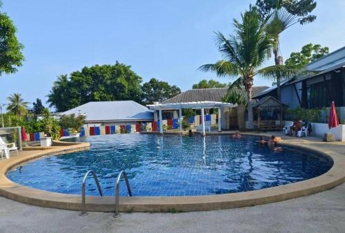 a large swimming pool with people in the water at Sirimaya Garden Home & Residence in Bang Rak Beach