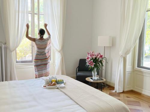 a woman looking out of a window in a bedroom at Montreux Luxury Suite in Montreux