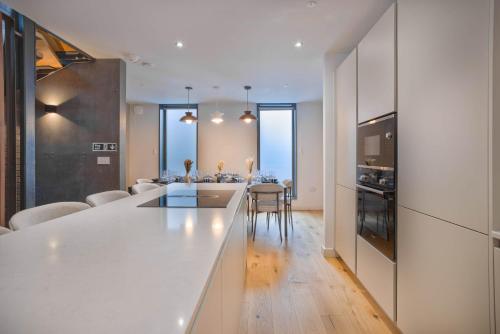 a kitchen and living room with a white counter top at Townhouse East by CasaCity in Manchester