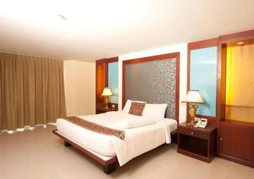 a bedroom with a large bed and a large window at Convenient Grand Plus Hotel Suvarnabhumi in Lat Krabang