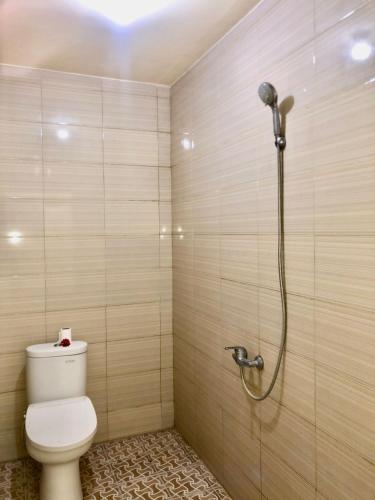 a bathroom with a shower with a toilet in it at Santika Guest House in Ubud
