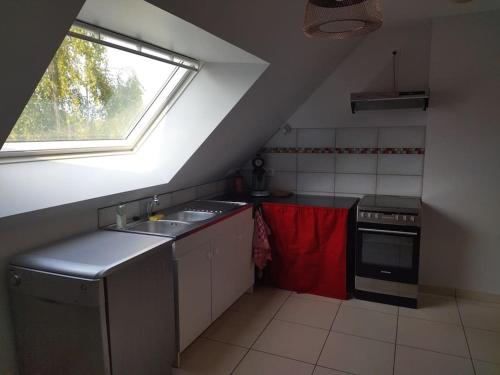 une cuisine mansardée avec un évier et une fenêtre dans l'établissement M-Houssa, à Saint-Laurent