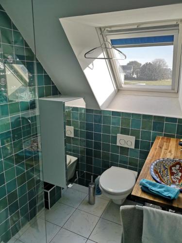 une salle de bain avec toilettes, lavabo et fenêtre dans l'établissement Maison dans le sud du Morbihan près de la mer, à Damgan