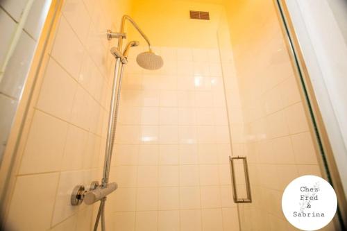 une douche avec une porte vitrée dans une salle de bain dans l'établissement Le studio des Halles, au Havre