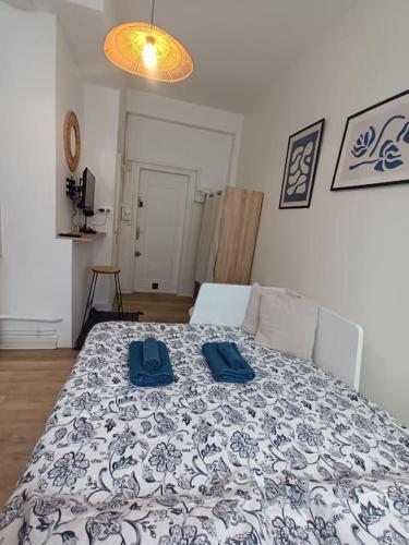 - une chambre dotée d'un lit avec deux chaussures bleues dans l'établissement Le studio des Halles, au Havre